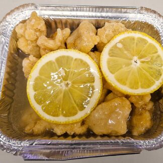 Takeaway deep-fried chicken pieces in lemon-flavored sauce